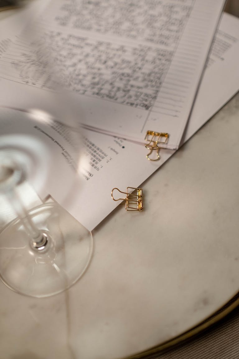 Stylish arrangement of documents with golden binder clips on a marble table.